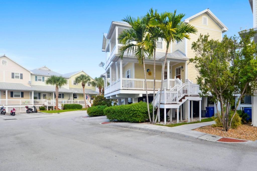 a street in front of a house with palm trees at Coral Garden by AvantStay Great Location w Balcony Shared Pool in Stock Island