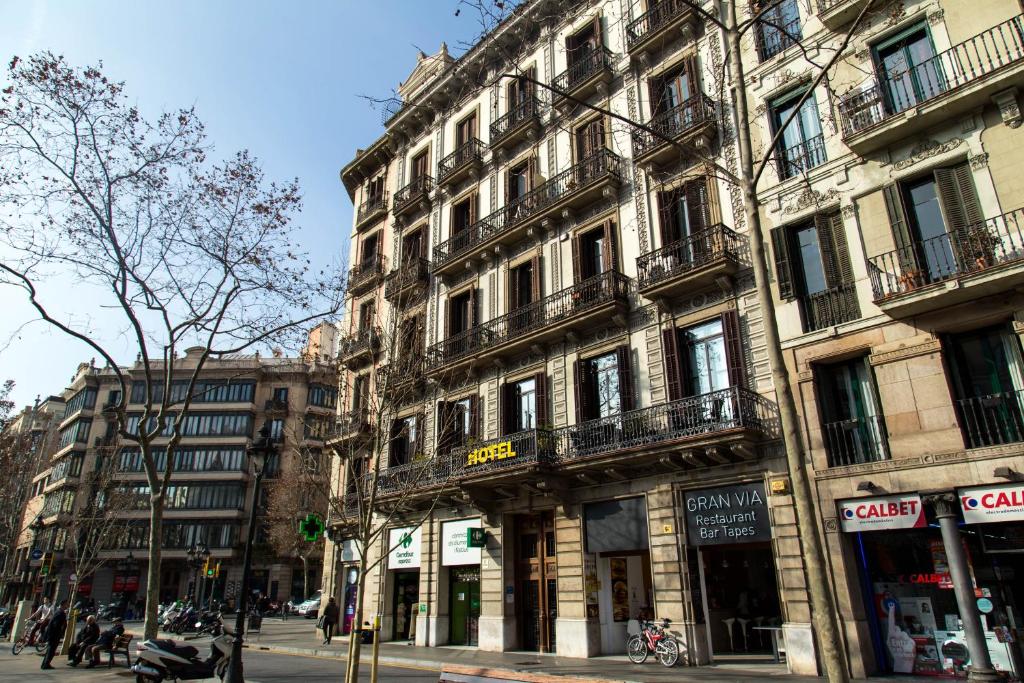 a tall building on a city street with people standing outside at Center Gran Via in Barcelona
