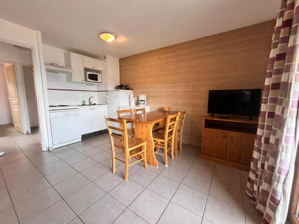 une cuisine avec une table et des chaises et une télévision dans l'établissement Charmant appartement familial avec balcon, parking inclus - FR-1-593-132, aux Angles