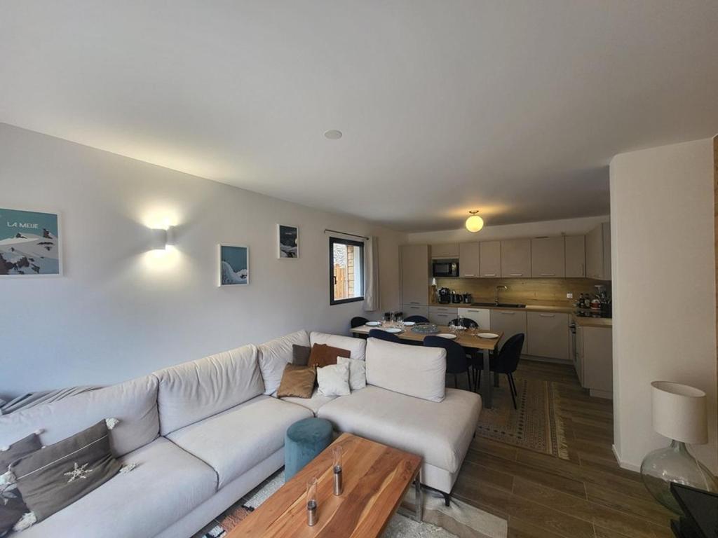 un salon avec un canapé blanc et une cuisine dans l'établissement Spacieux appartement 3 chambres, terrasse et jardin à Montgenèvre - FR-1-266-250, à Montgenèvre