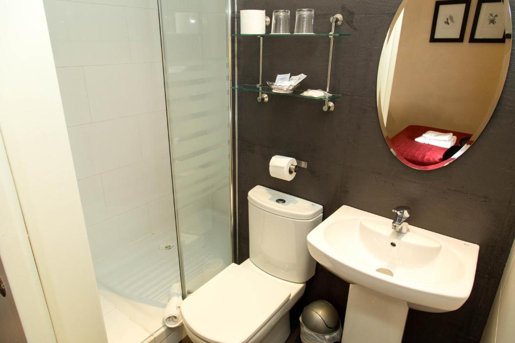 a bathroom with a toilet and a sink and a mirror at Center Gran Via in Barcelona