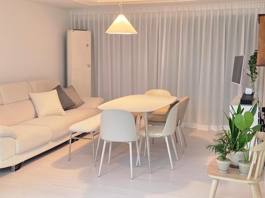 a living room with a couch and a table and chairs at The Bom Stay in Daegu