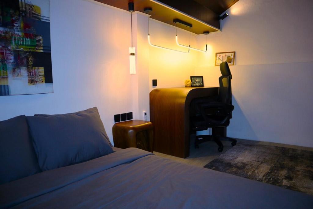 Un dormitorio con una cama y un escritorio con una silla. en Happy Spiritus Apartment, en Tabanan