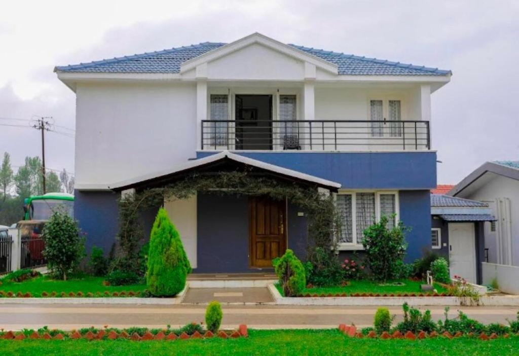 a house with a blue and white house at Maria villa in Ooty