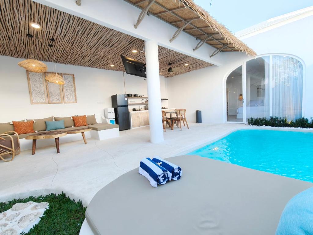 a villa with a swimming pool and a living room at Villa Vinodayan Uluwatu by LODGELINK BALI in Uluwatu