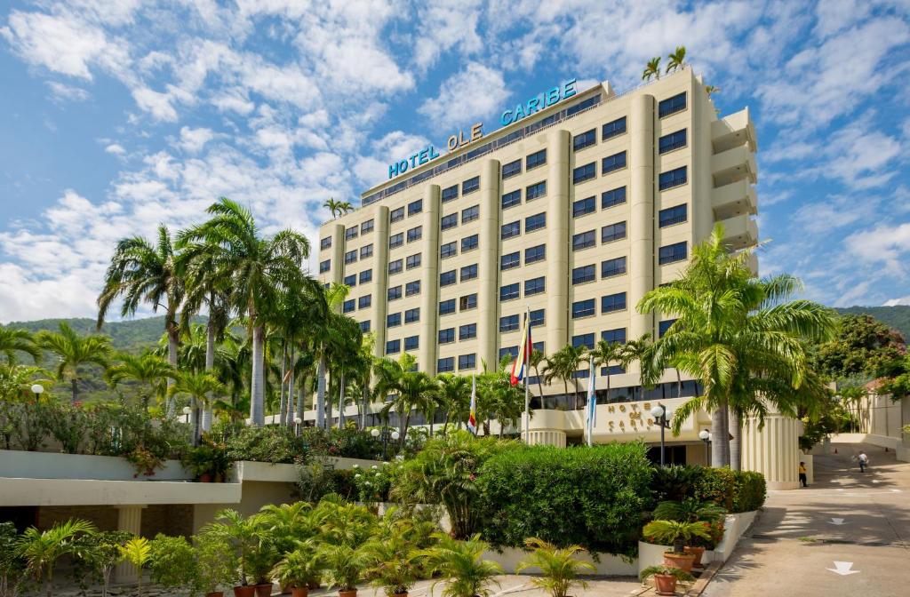 un hotel con palmeras delante en Hotel Olé Caribe, en Macuto