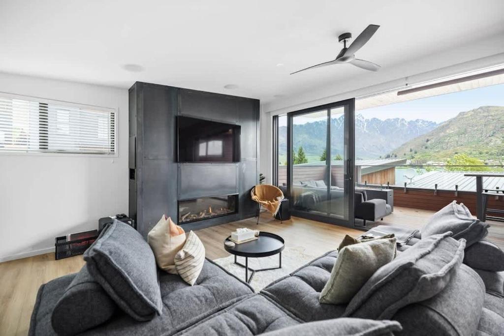 Una sala de estar con un sofá y una chimenea. en Kohatu Ora, en Queenstown