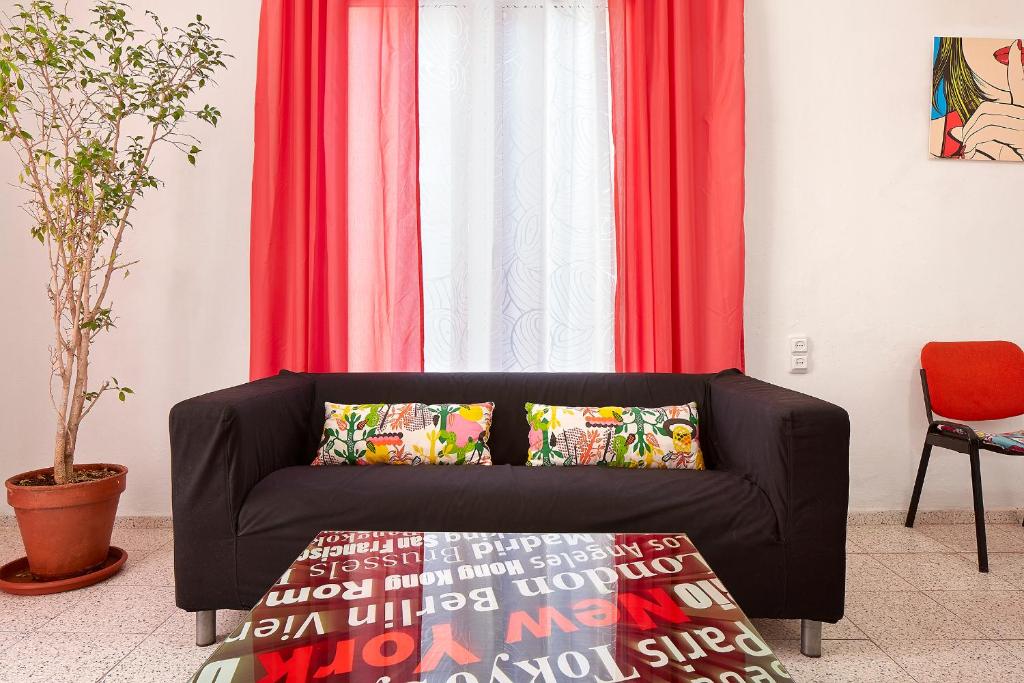 a black couch in front of a window with red curtains at Hostal River in Barcelona