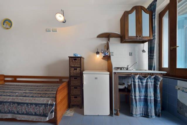 a kitchen with a bed and a sink in a room at Azzurromare Residence in Procida