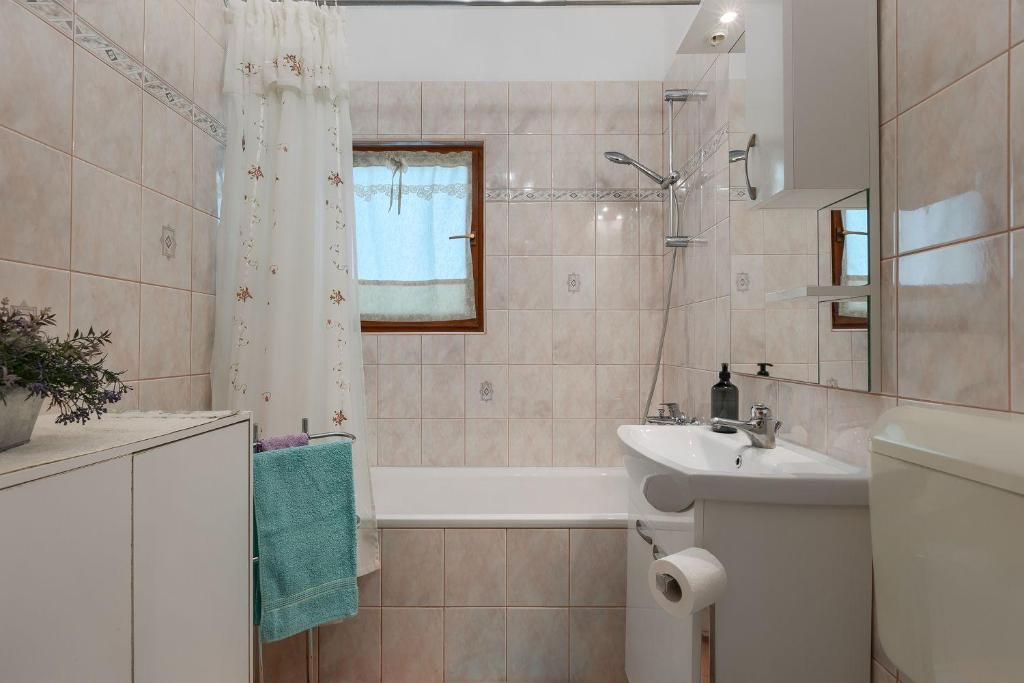 łazienka z białą wanną i umywalką w obiekcie Komplett umzäuntes Ferienhaus mit Klima, WLAN w mieście Rakalj