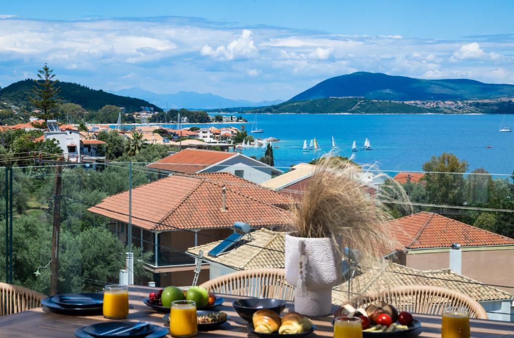 einen Tisch mit Nahrung und Blick auf das Wasser in der Unterkunft Pillow Apartments in Nikiana