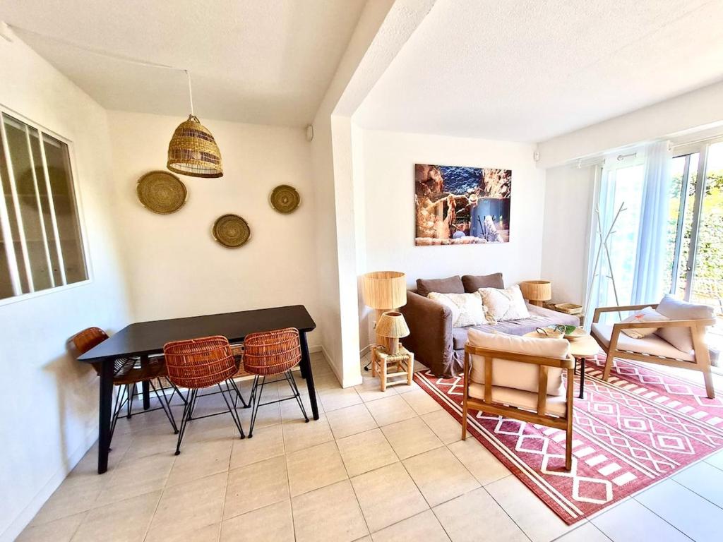 un salon avec une table et un canapé dans l'établissement Rez de jardin 400 m de la mer, à Cavalaire-sur-Mer