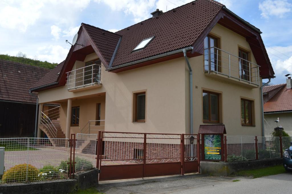 een huis met een bruin dak en een hek bij Privát Lenka in Prosiek