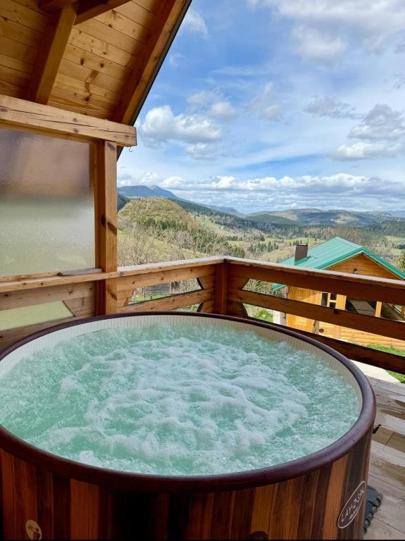 a large hot tub on the balcony of a cabin at Sunset Lux Cottage Ravna Planina Pale - Jahorina in Pale