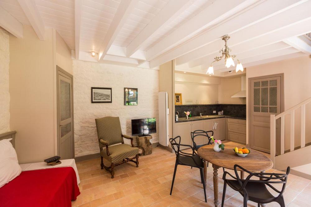 ein Wohnzimmer mit Tisch und Küche in der Unterkunft Chateau de Lourdes in Saint-Méloir-des-Ondes