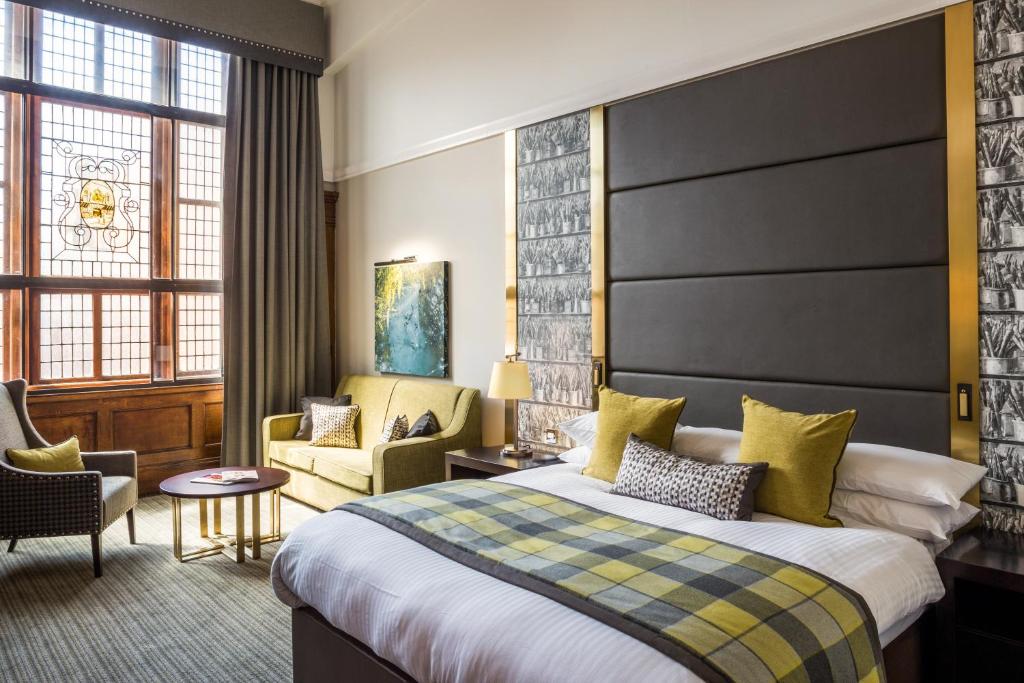 um quarto de hotel com uma cama e uma cadeira em ABode Glasgow em Glasgow