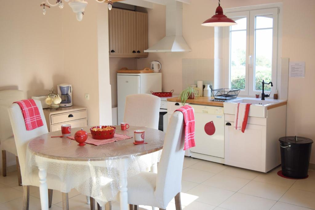 een keuken met een tafel en stoelen en een wastafel bij Ferme du lin : Angelin in Gueschart
