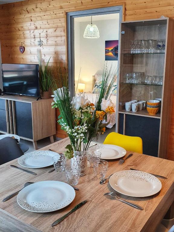 une table en bois avec des assiettes et des ustensiles dessus dans l'établissement Croisse Baulet Pied des pistes Parking 3 épis, à La Giettaz