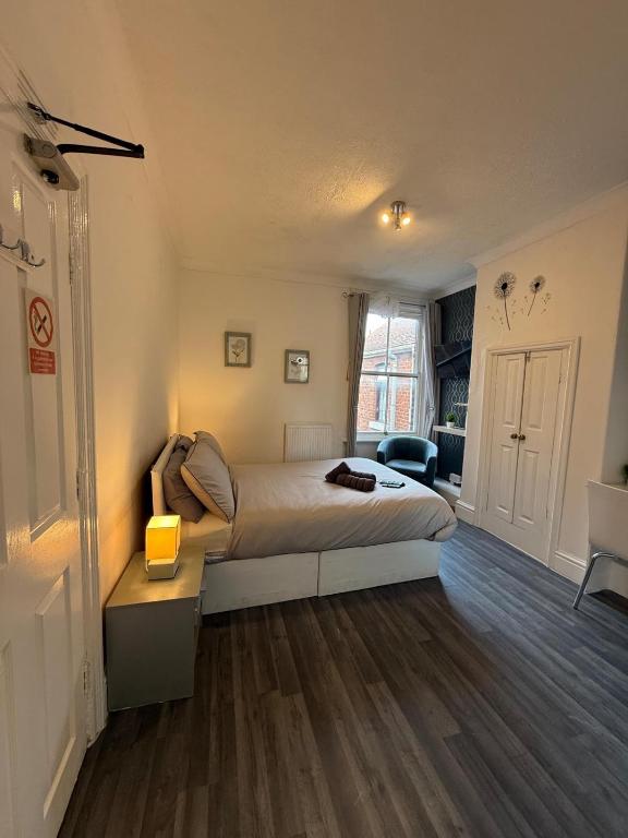 a bedroom with a bed and a desk with a lamp at Daville Hotel Blackpool in Blackpool
