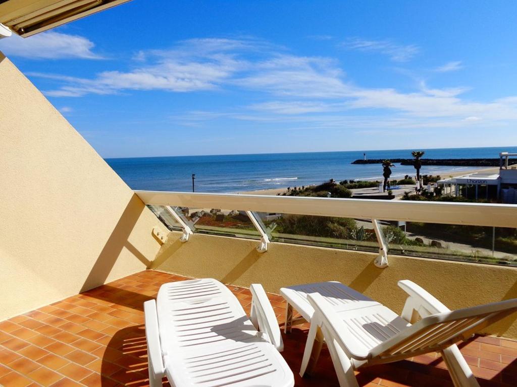 un balcon avec des chaises et une table et l'océan dans l'établissement Studio Héliopolis C 36 - 4 personnes, au Cap d'Agde