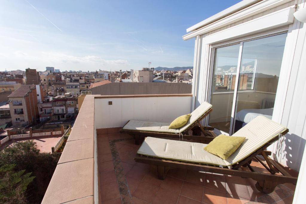 a balcony with two chairs and a view of a city at Gaudi Views Apartment in Barcelona