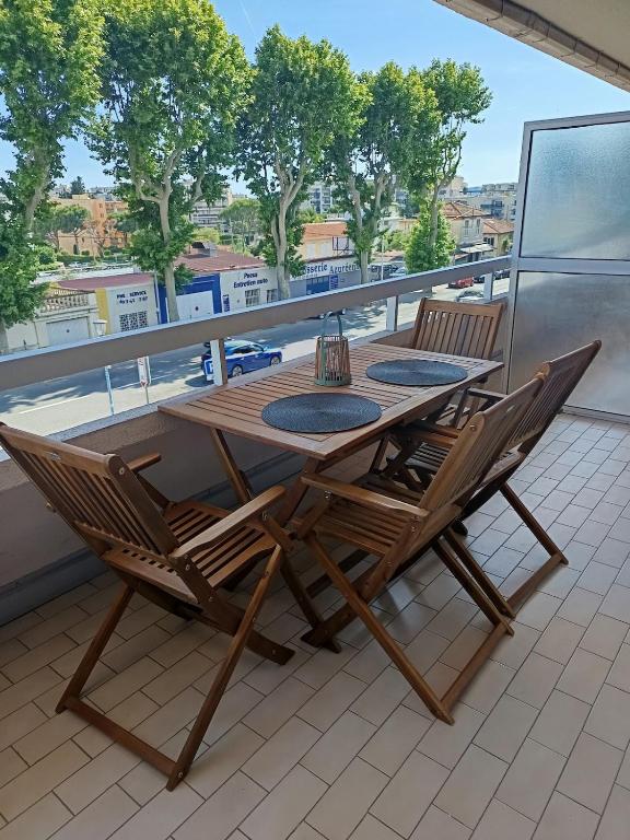 une table et des chaises en bois assises sur un balcon dans l'établissement Nice studio 5 minutes walk from the beach, à Cagnes-sur-Mer