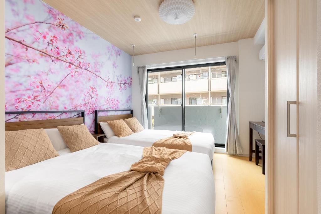 two beds in a room with aakura mural at 幡ヶ谷2丁目 in Tokyo