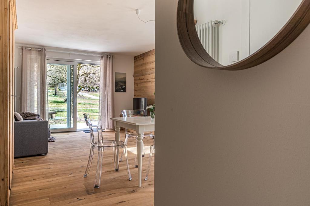 MassimenoにあるCasa Cozzini - 3 appartamenti nella naturaのテーブルと鏡のあるリビングルーム