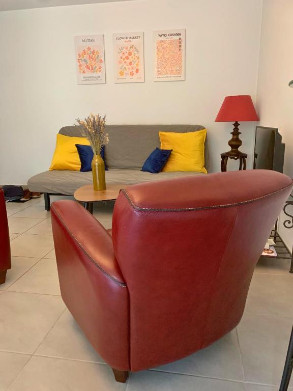 - un fauteuil en cuir dans le salon avec canapé dans l'établissement La Houblonnière, à Colmar