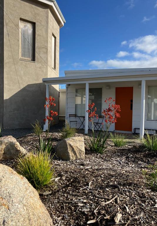 a house with red flowers in front of it at The Rectory Zeehan in Zeehan