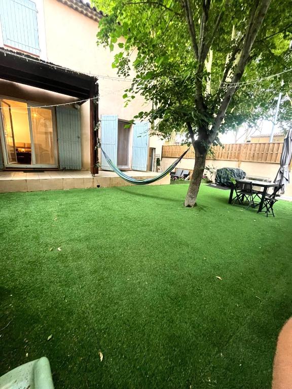 - un hamac suspendu à un arbre dans la cour dans l'établissement Grand jardin - Climatisation - parking privatif, à Nîmes