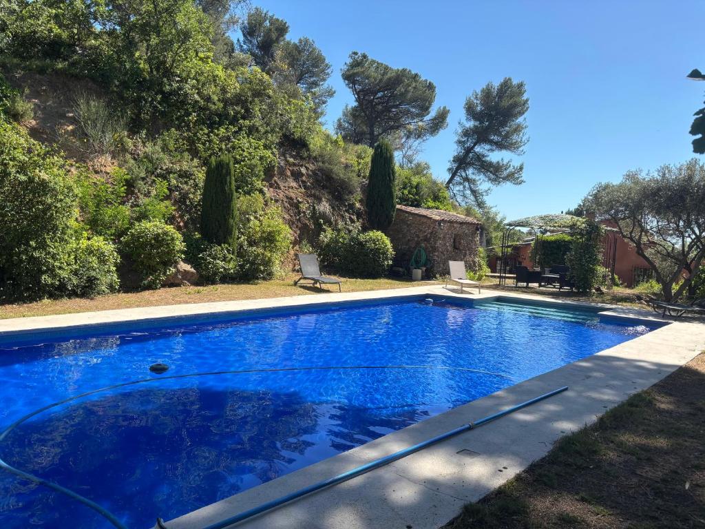 une grande piscine bleue dans une cour dans l'établissement La GUIRAMANDE, à Aix-en-Provence