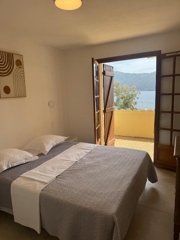 a bedroom with a bed and a sliding glass door at Appartement sur la plage in Casaglione