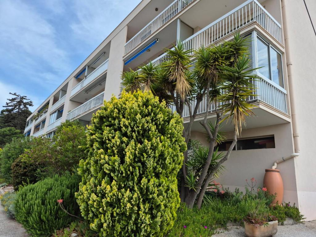 un immeuble d'appartements avec une brousse en face dans l'établissement Appartement studio Fabregas vue mer, à La Seyne-sur-Mer