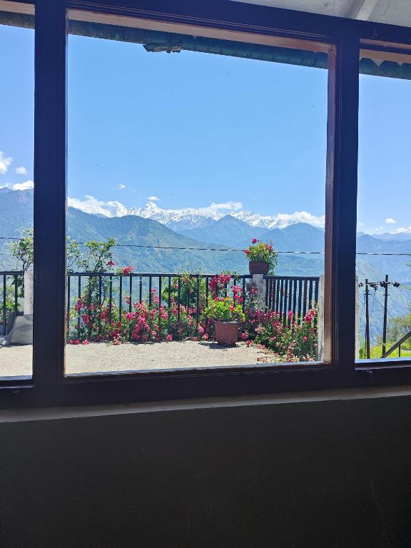 a window with a view of the water and mountains at Geeta Homestay in Munsyari