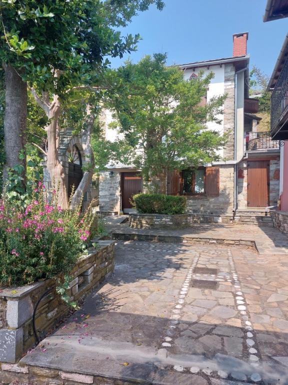 a courtyard of a house with a tree and flowers at Παραδοσιακός ξενώνας Ναϊάς in Zagora