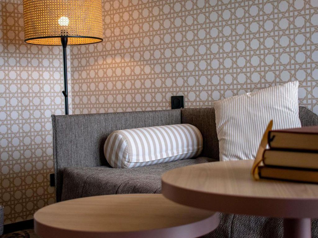 a living room with a chair and a table at Mercure Granville Le Grand Large in Granville