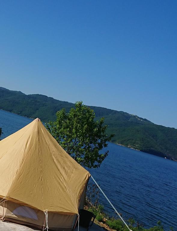 a tent sitting next to a body of water at Lakeview Glamping in Staro Myasto