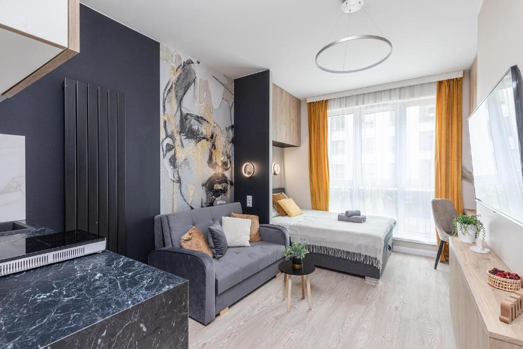 a living room with a couch and a bed at miniSTUDIOS URSUS by VAYA STAYS in Warsaw