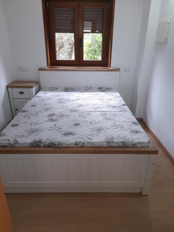 a white bed in a room with a window at Chalé da Fonte - T2 in Geres