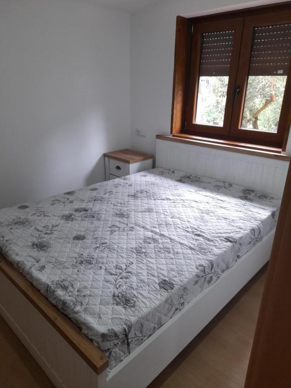 a bed in a bedroom with a window at Chalé da Fonte - T2 in Geres