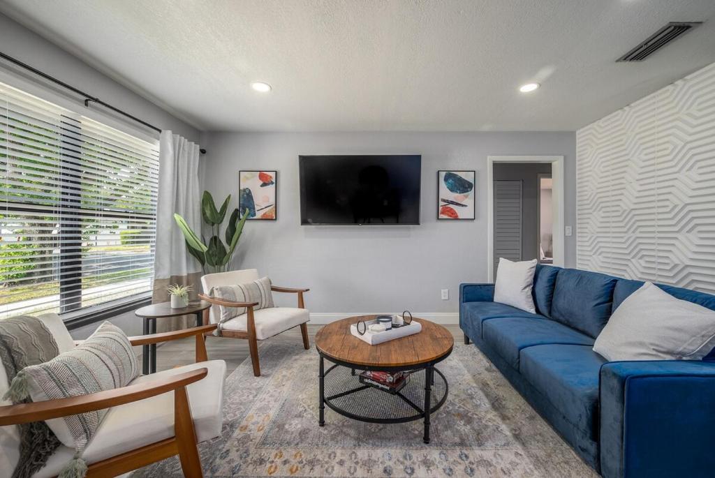 Modern 2BR DownTown Home with King Bed, Long Stays, WiFi, Netflix في أورلاندو: غرفة معيشة مع أريكة زرقاء وطاولة