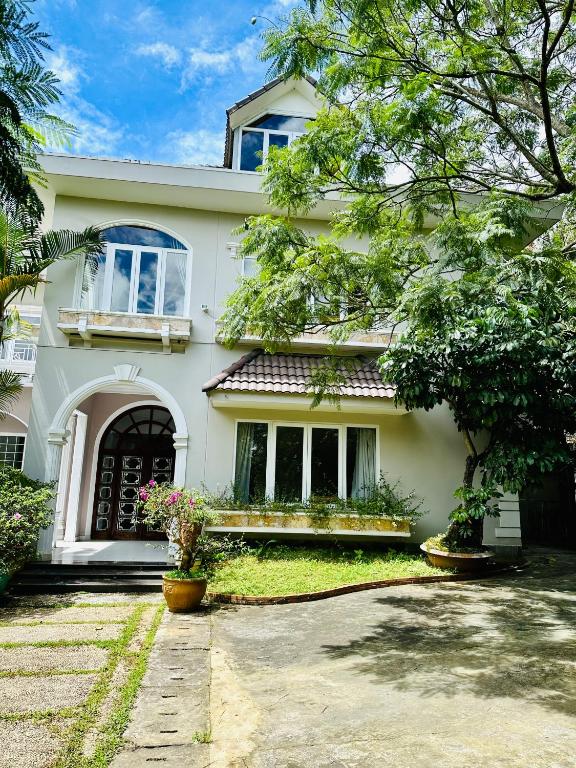 a white house with flowers in front of it at Jakaranda Villa Dalat in Da Lat