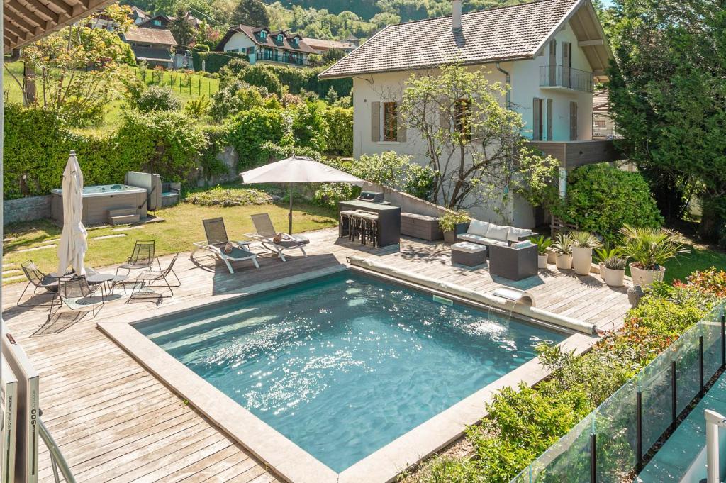 une piscine avec une terrasse et une maison dans l'établissement M62 Jolie villa Veyrier-du-lac avec Jacuzzi et vue sur lac, à Veyrier-du-Lac