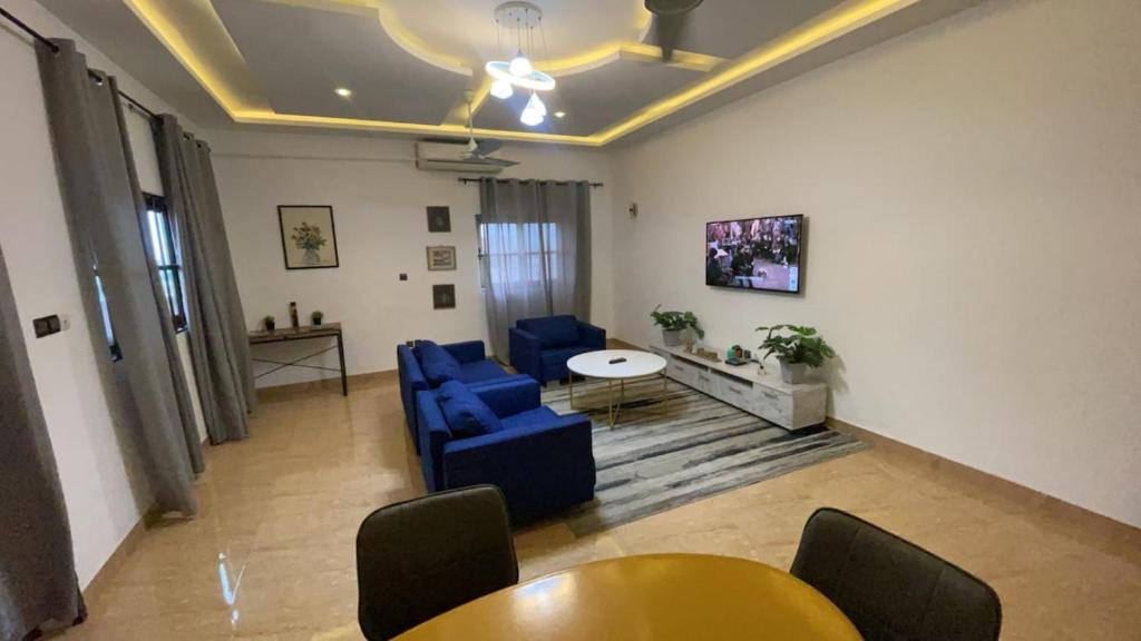 Una sala de estar con sillas azules y una mesa. en Cozy, Elegant, Central, Peaceful, en Cotonou