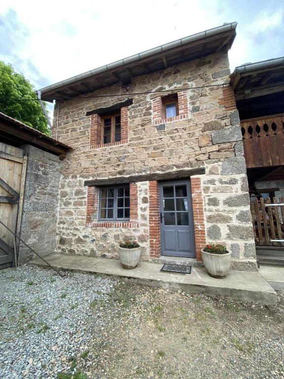 une maison en pierre avec deux fenêtres et une porte dans l'établissement Le fournil, à Saint-Didier-sur-Rochefort