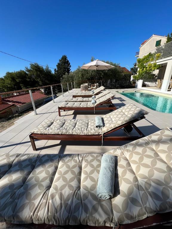 a group of beds sitting next to a swimming pool at seaview apartment - villa a’more in Milna