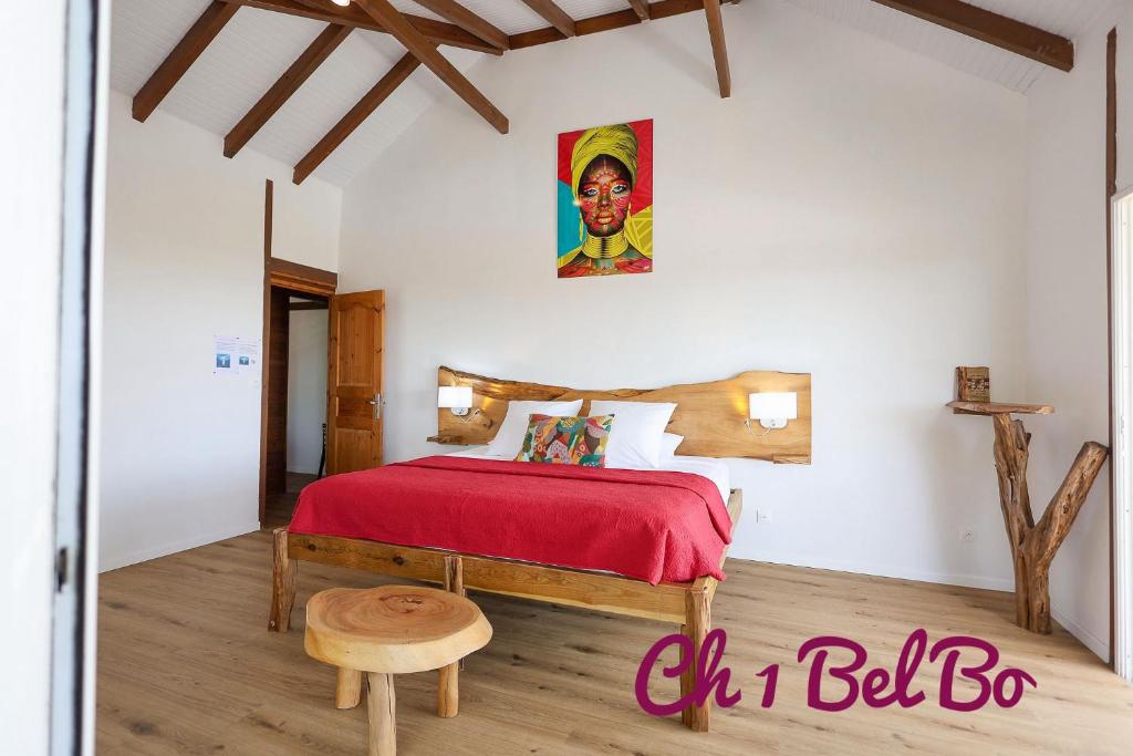 - une chambre avec un lit doté d'un couvre-lit rouge dans l'établissement Haut de villa BEL BO & Bas de villa Tibo accès mer, à Deshaies
