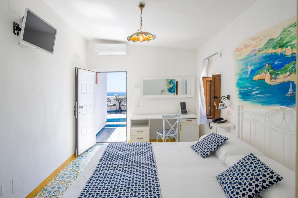 a bedroom with a bed with blue and white pillows at Hotel Costa Diva in Praiano