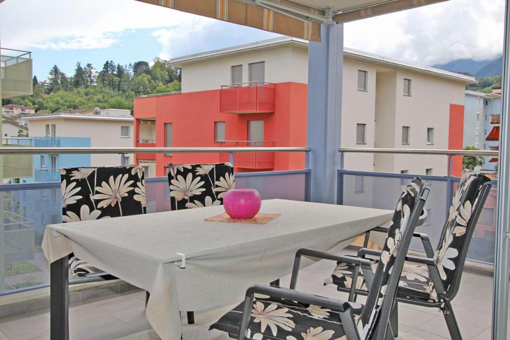 a table on a balcony with a pink vase on it at Casa ai Faggi, 3-Zimmerwohnung, 3 Stock by HolAp SA in Losone